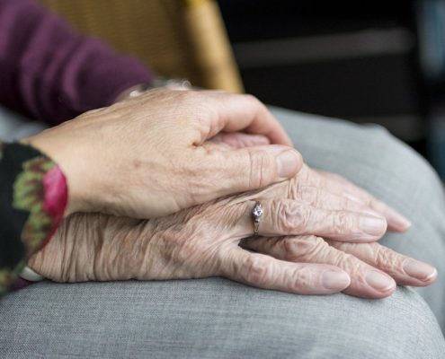 how does dementia affect the brain, woman holding elderly woman's hand