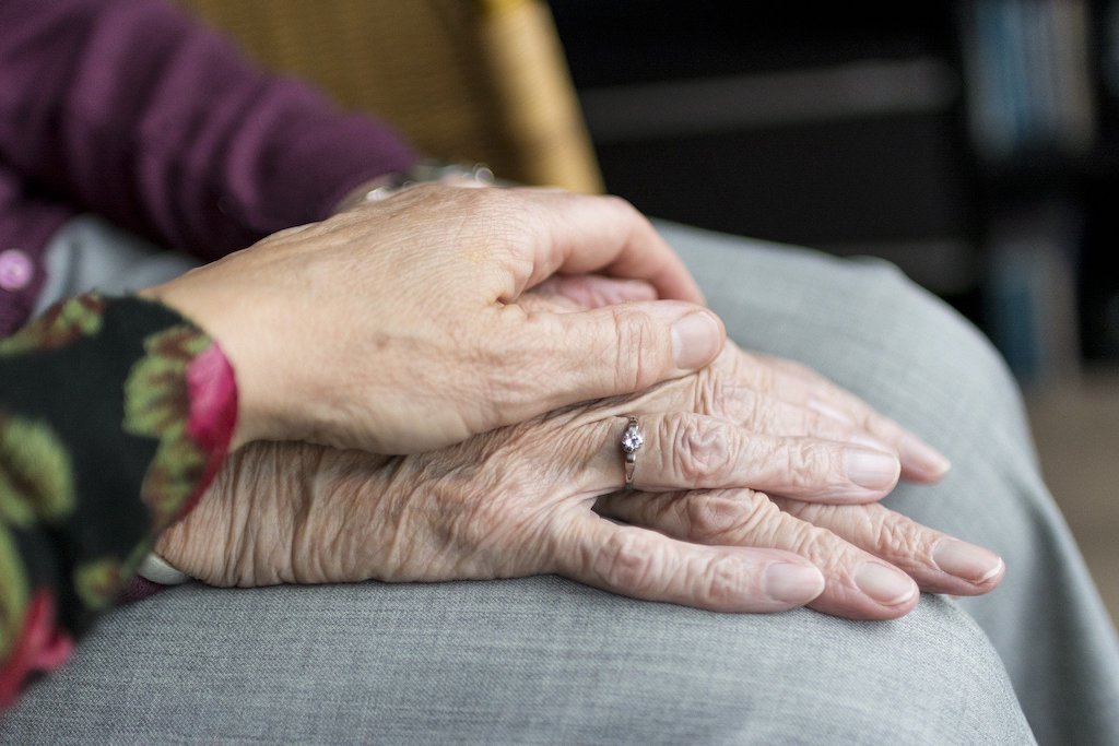 how does dementia affect the brain, woman holding elderly woman's hand
