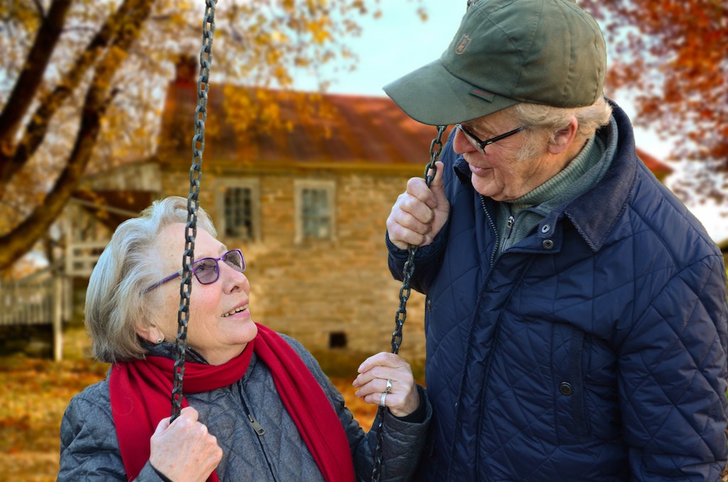assisted living, elderly woman swinging and talking to elderly man